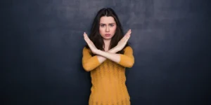 امرأة تشكل علامة إكس بيديها. في اشارة للتعامل مع الشخصية النرجسية بصرامة.