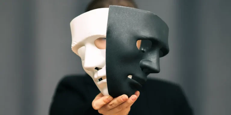 شخص يضع على يده قناع أسود وخلف القناع يظهر جزء من قناع أبيض، في إشارة إلى وجود حقائق خفية عن النرجسية.