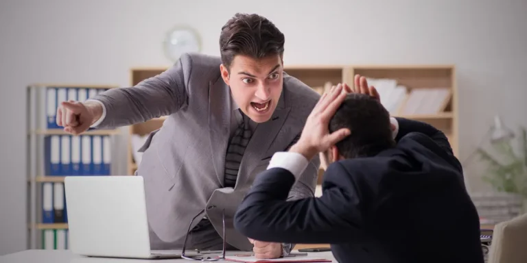 مدير يصرخ في وجه موظفه. تعكس الصورة طريقة الموظف في التعامل مع الشخص النرجسي في العمل.